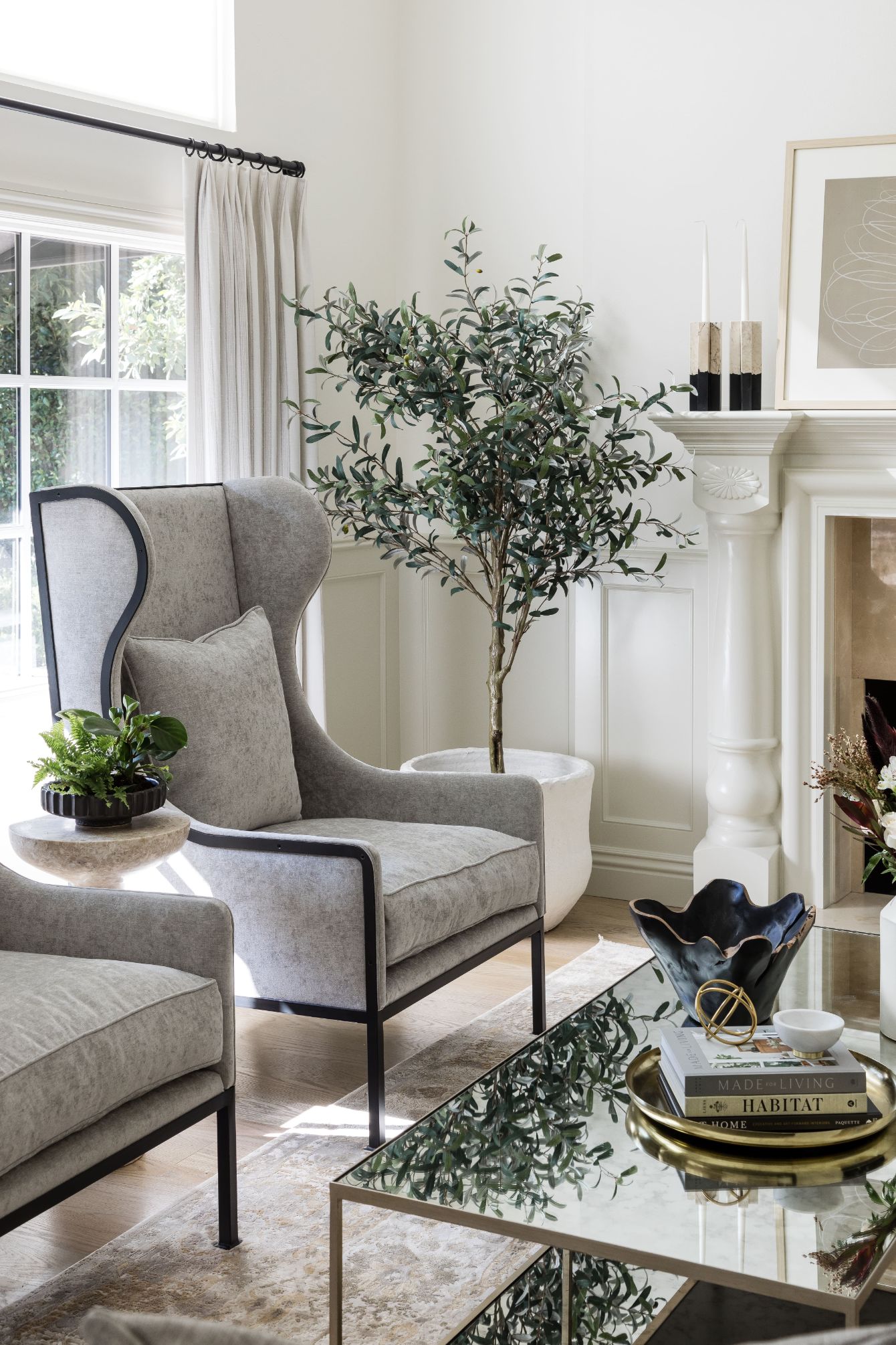 living area detail with wingback chair and large tree in the corner