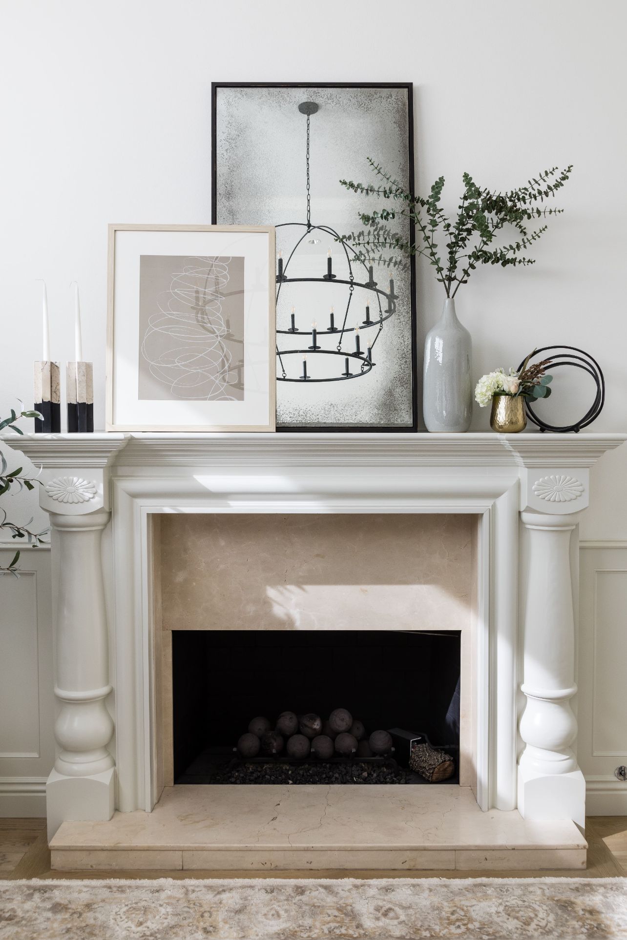 fireplace with artwork and plant on mantle