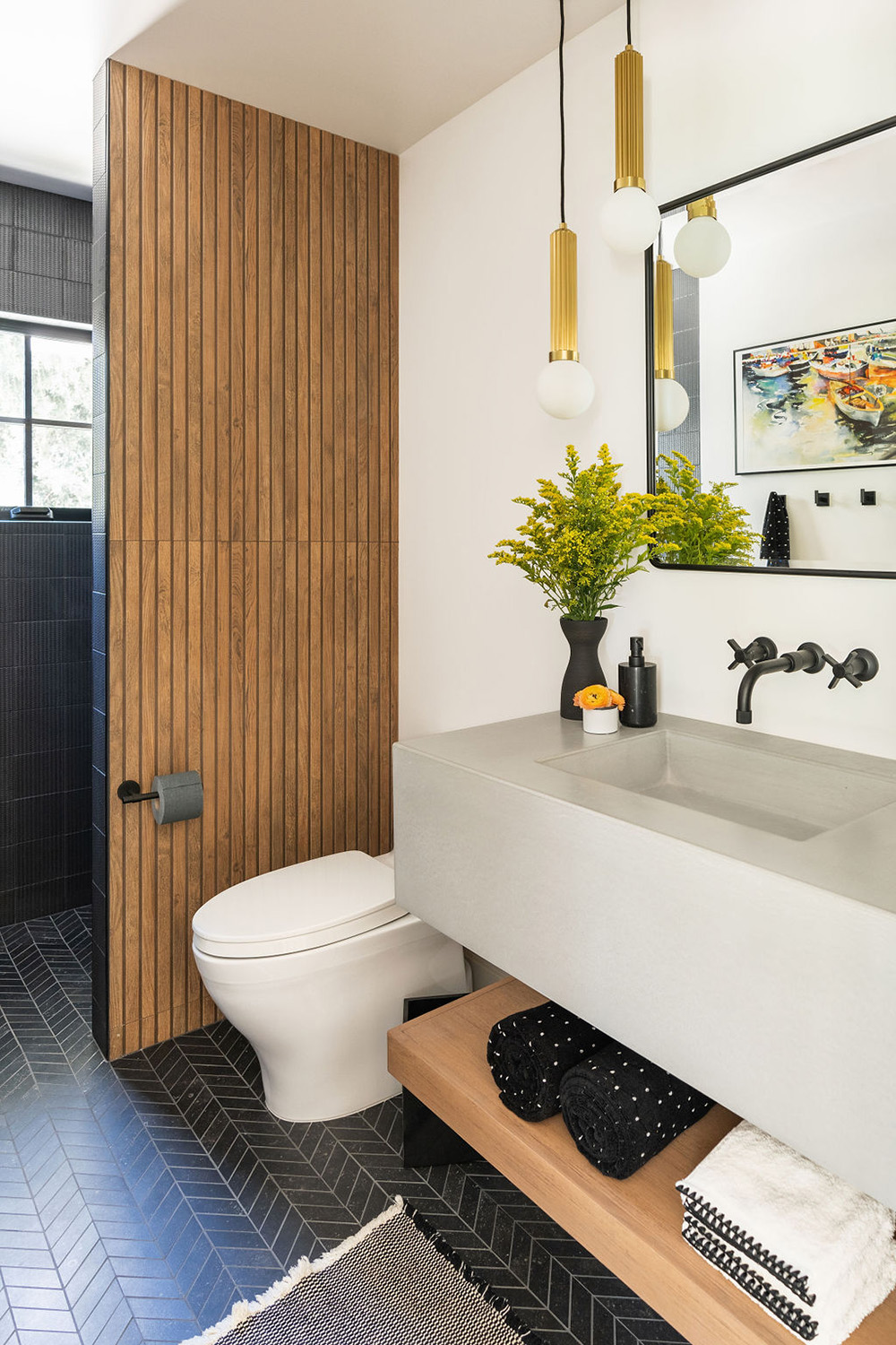 bathroom design with dark gray shower tiles, wood accent wall and herringbone floor tile