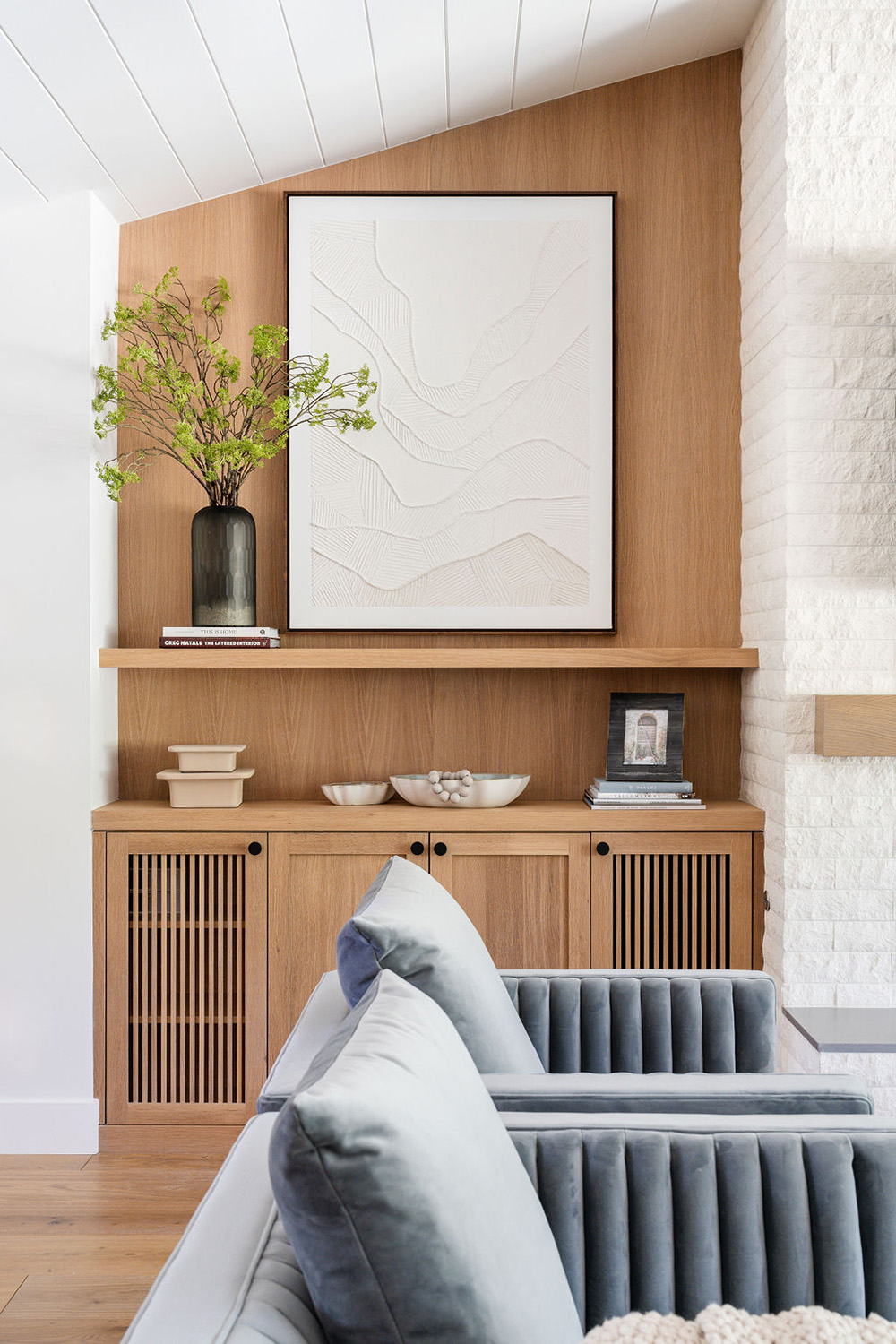 living room nook with wood accents and large white artwork