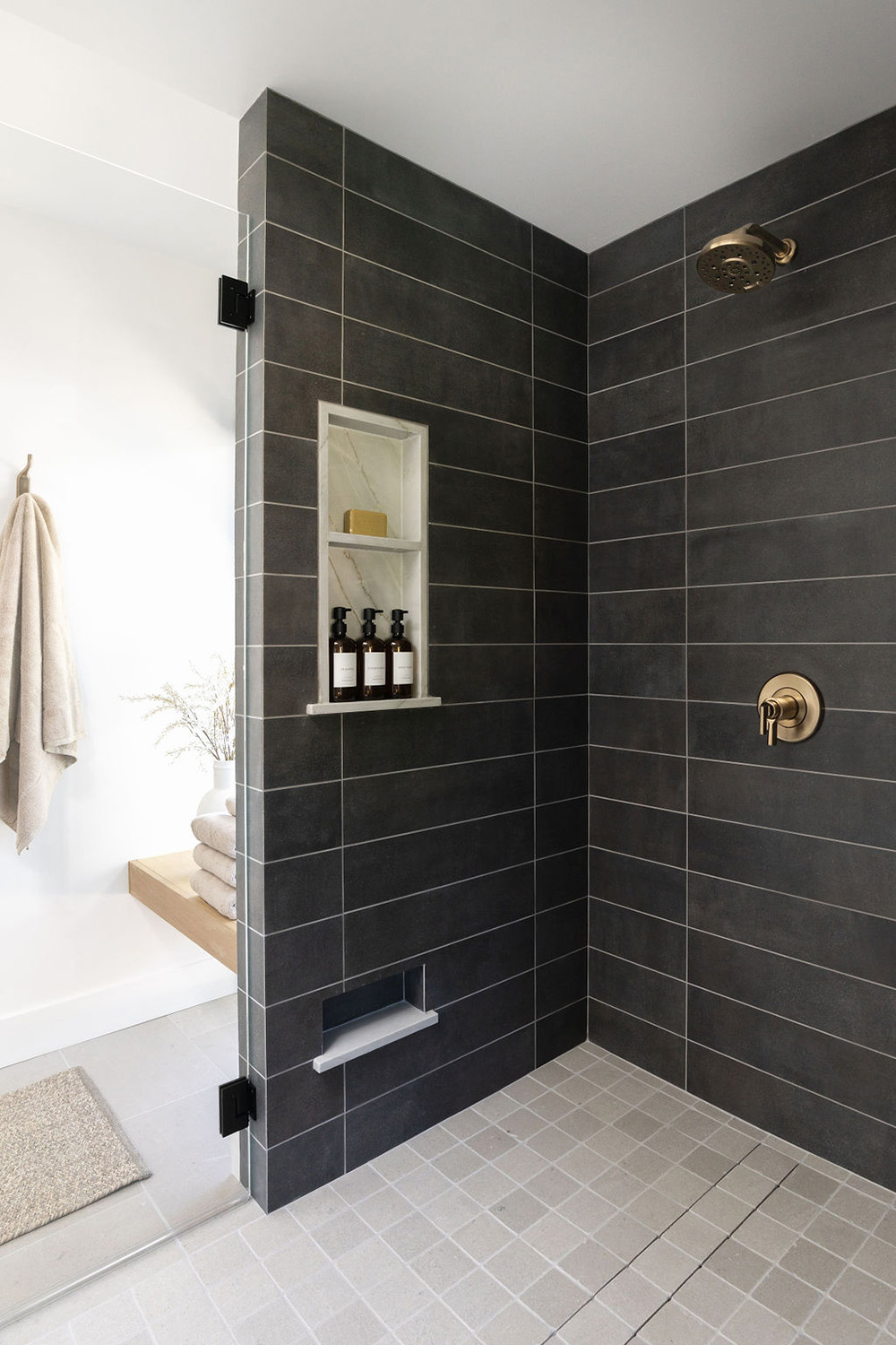 modern walk-in shower design with dark tile and bright fixtures