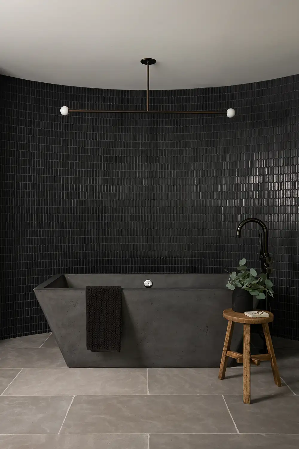 Gorgeous modern upscale bathroom with black wall tile and tub